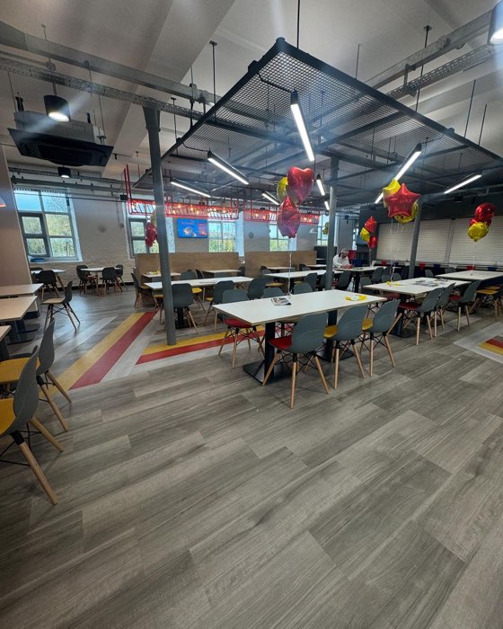 Staff canteen and breakout space with painted floor graphics, tables and seating, freshly refurbished
