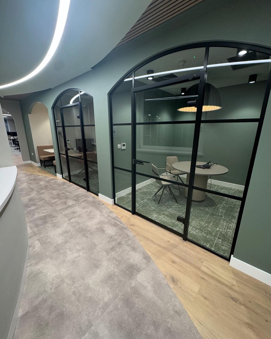 Freshly decorated office corridor with glazed meeting pods and feature colour walls, completed by MKL Decorating